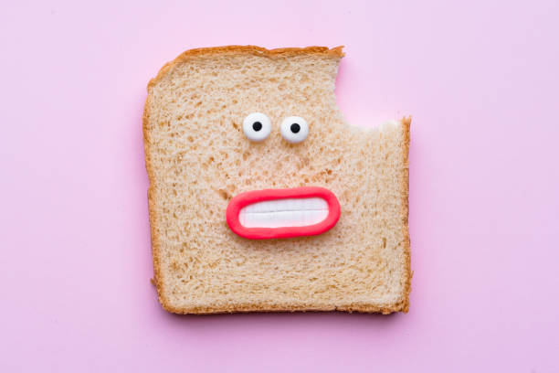 sliced bread with faces on pink background - junk food stock pictures, royalty-free photos & images