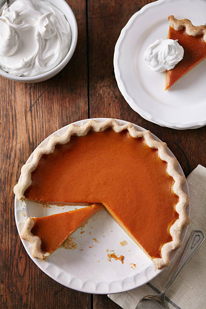sliced pumpkin pie on wood table, from above - food stock pictures, royalty-free photos & images