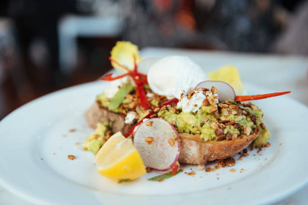 smashed avocado and poached eggs on sourdough bread - food stock pictures, royalty-free photos & images