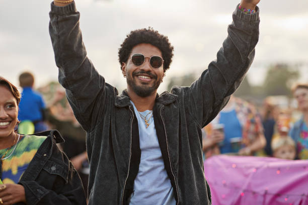 smiling man dancing with arms raised by woman - concert stock pictures, royalty-free photos & images
