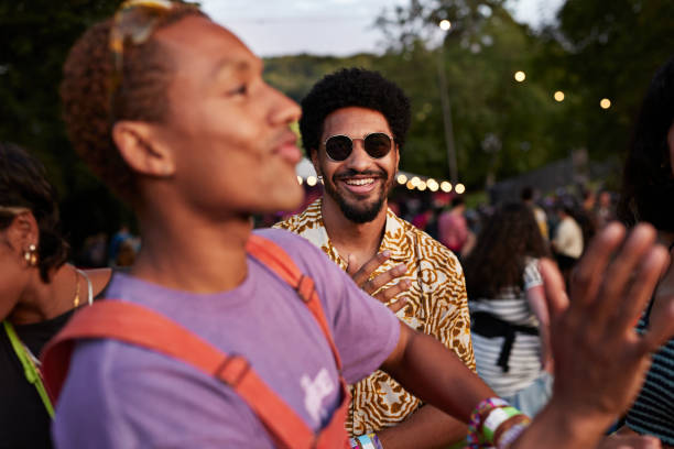 smiling man looking at friend dancing carefree - concert stock pictures, royalty-free photos & images
