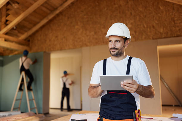 smiling manual worker using touchpad at construction site. - home decoration stock pictures, royalty-free photos & images