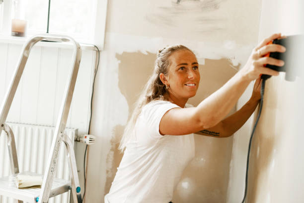 smiling woman sanding wall while renovating home - home decoration stock pictures, royalty-free photos & images