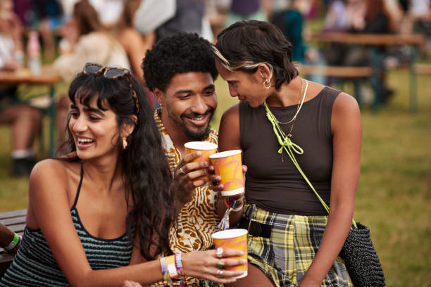 smiling woman talking to boyfriend by friend - concert stock pictures, royalty-free photos & images