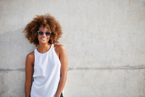 smiling woman wearing tank top and sunglasses - fashion stock pictures, royalty-free photos & images