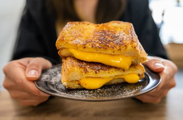 someone holding a cheese toast before eating. - junk food stock pictures, royalty-free photos & images
