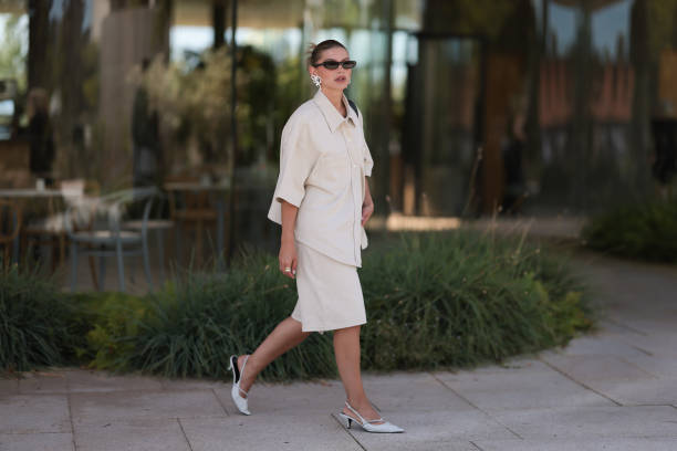 Sophia Geiss is seen wearing narrow black sunglasses from Saint Laurent, white earrings in the shape of a bow, a two-piece consisting of an oversized...