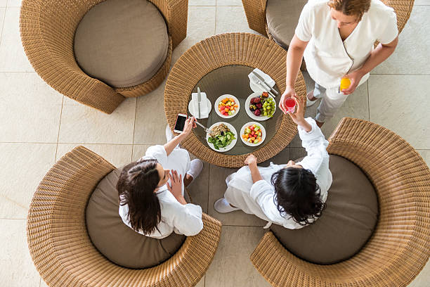 spa therapist serving fresh juice to two middle eastern women - food stock pictures, royalty-free photos & images