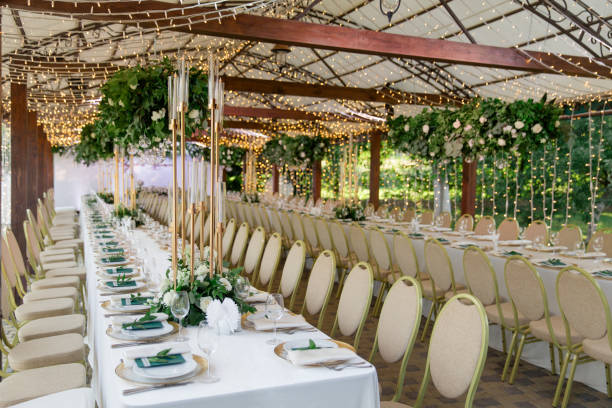 spacious wedding reception decorated with lights and greenery - garden decoration stock pictures, royalty-free photos & images