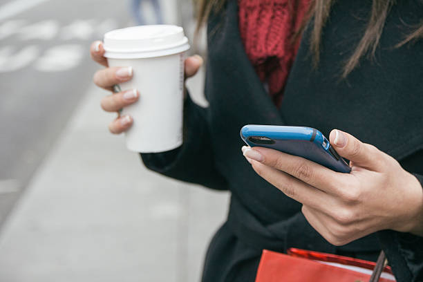 spain, young woman with smartphone and coffee to go, close-up - junk food stock pictures, royalty-free photos & images