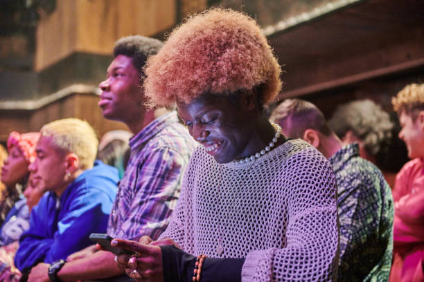 spectator messaging on their phone at a music event. - concert stock pictures, royalty-free photos & images