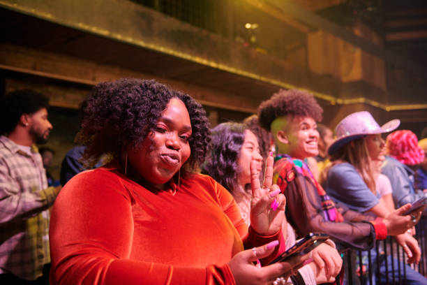 spectator pouting and showing the peace sign at a music event. - concert stock pictures, royalty-free photos & images