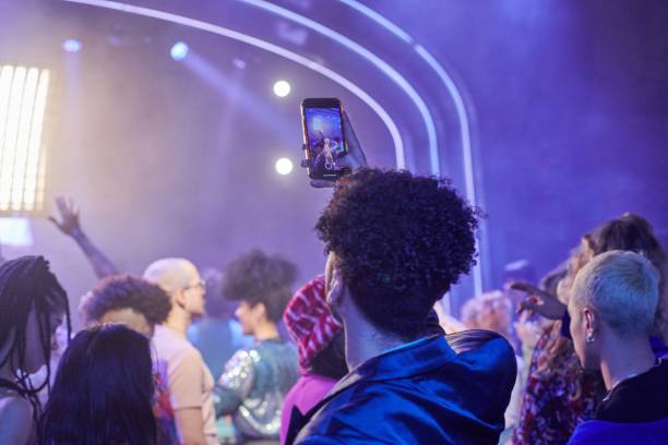 spectator recording a video with phone at a music event. - concert stock pictures, royalty-free photos & images