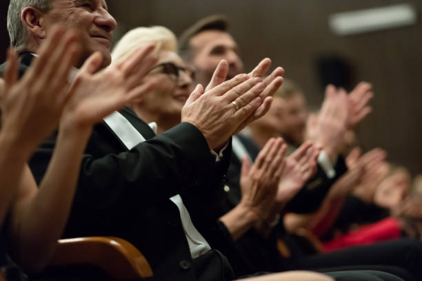 spectators clapping in the theater, focus on hands - concert stock pictures, royalty-free photos & images