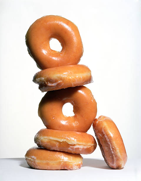 stack of glazed donuts - junk food stock pictures, royalty-free photos & images
