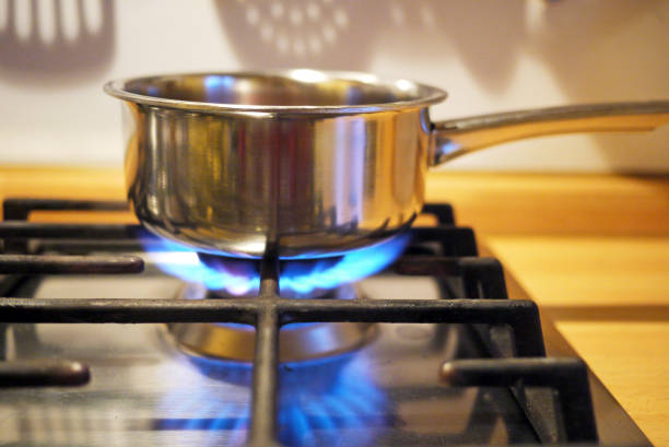 stainless steel pan on gas stove - food stockfoto's en -beelden