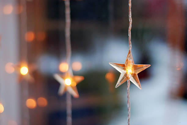 star shaped christmas lights in a window - home decoration photos et images de collection