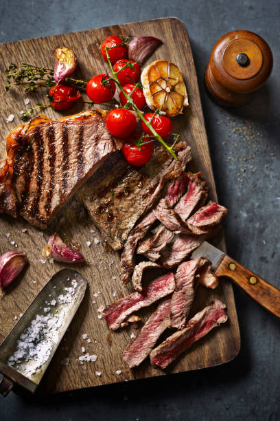 steak cut on board with roasted veg - food stock pictures, royalty-free photos & images