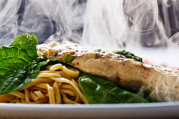steaming seared chicken breast with pesto, noodles and spinach - food stock pictures, royalty-free photos & images