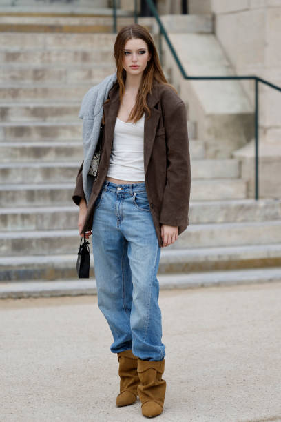 Stella Hanan wears white top, brown blazer, blue jeans, brown suede boots, outside Chanel, during the Womenswear Fall/Winter 2025/2026 as part of...