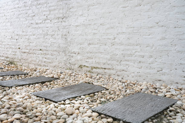 stepping stones and white brick wall - garden decoration stock pictures, royalty-free photos & images