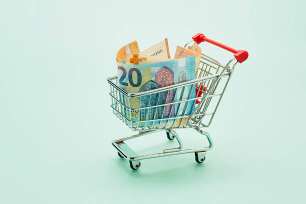 still life of shopping cart and euro notes on turquoise background - food stock pictures, royalty-free photos & images