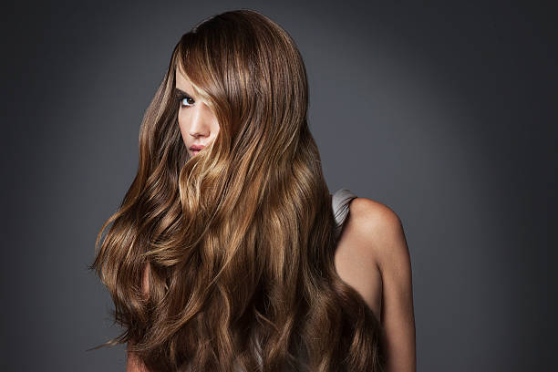 studio portrait of young woman with long brown hair - hairstyle stock-fotos und bilder