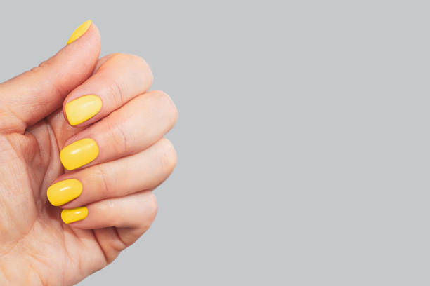 stylish neon yellow manicure on gray background. - nails art stock pictures, royalty-free photos & images