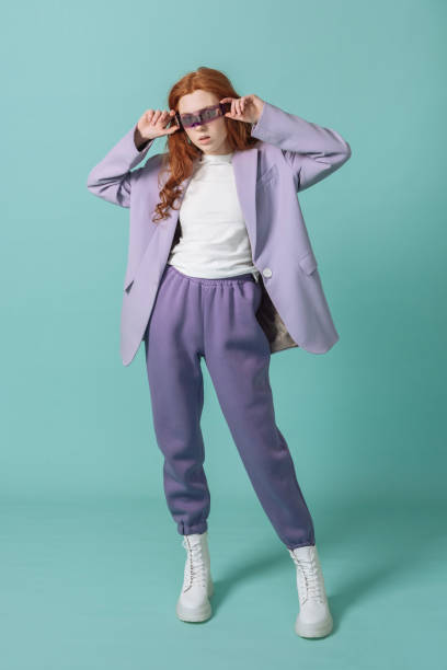 stylish young model in colored clothes posing in the studio on a colored background in fashionable technological glasses of virtual reality. fashion concept. - fashion stock pictures, royalty-free photos & images