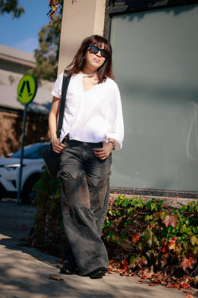 Su Shan Leong wearing Y/Project denim pants, Facetasm white shirt, Maison Margiela Tabis and Lamaire bag during Australian Fashion Week Presented By...