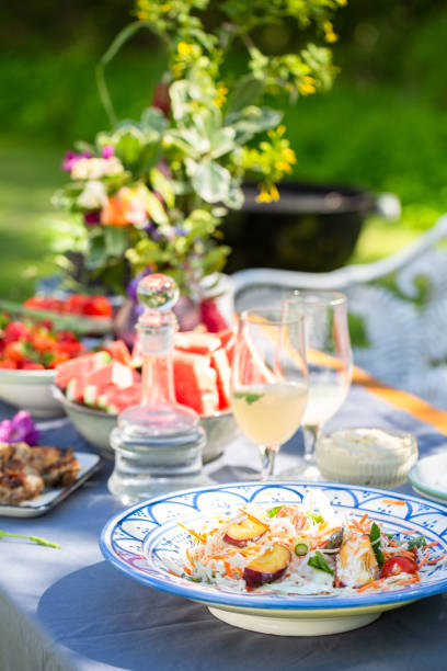 summer outdoor table setting with salad, food and flowers - garden decoration stock pictures, royalty-free photos & images