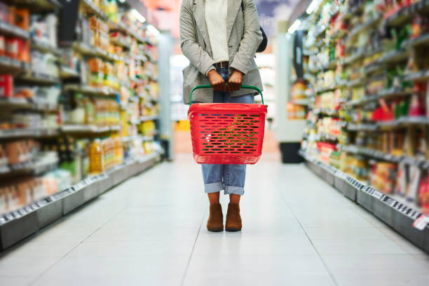 supermarket aisle, woman legs and basket for shopping in grocery store. customer, organic grocery shopping and healthy food on groceries sale shelf or eco friendly retail purchase in health shop - food stock pictures, royalty