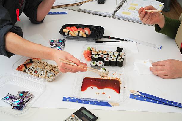 sushi lunch at work - junk food stock pictures, royalty-free photos & images