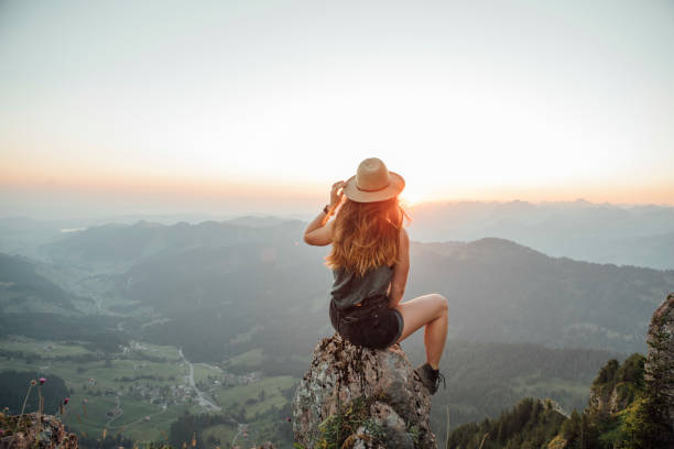 switzerland, grosser mythen, young woman on a hiking trip sitting on a rock at sunrise - travel stock pictures, royalty-free photos & images