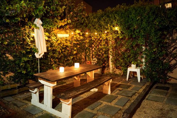 table with candle lights in backyard garden in evening - garden decoration stock pictures, royalty-free photos & images