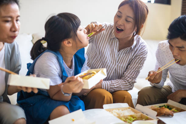 taiwanese family enjoying lunch time together at home - junk food stock pictures, royalty-free photos & images