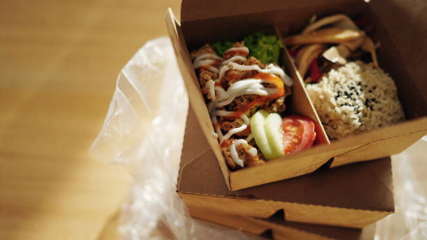take away asian food in recycled paper container on dining table - junk food stock pictures, royalty-free photos & images