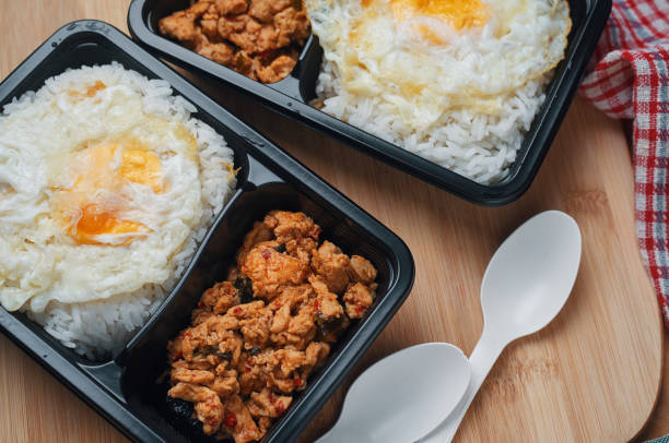 take home box stir-fried chicken basil with rice and fired egg - junk food stock pictures, royalty-free photos & images