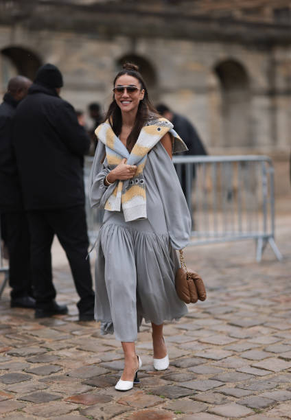 Tamara Kalinic was seen wearing white shoes, a grey dress, dark shades, a beige and grey scarf around her shoulders as well as a brown bag before the...