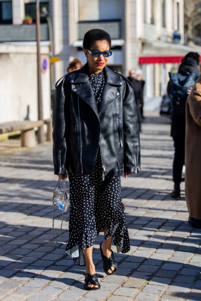 Tamu McPherson wears black oversized leather jacket, dress with dots print outside Stella McCartney during the Womenswear Fall/Winter 2024/2025 as...