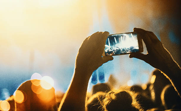 taping a concert with smartphone. - concert stock pictures, royalty-free photos & images