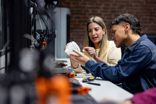 team of engineering students looking at a 3d printing model in class - fashion stock pictures, royalty-free photos & images