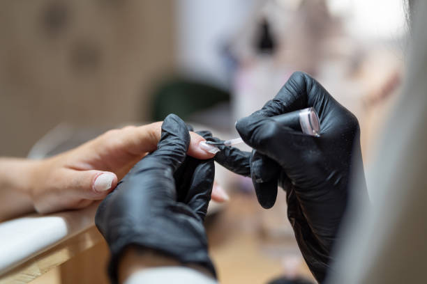 technician painting the nails of a client - nails art stock pictures, royalty-free photos & images