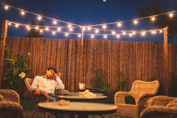 teen resting in the backyard patio listening to music - covid-19 series - garden decoration stock pictures, royalty-free photos & images