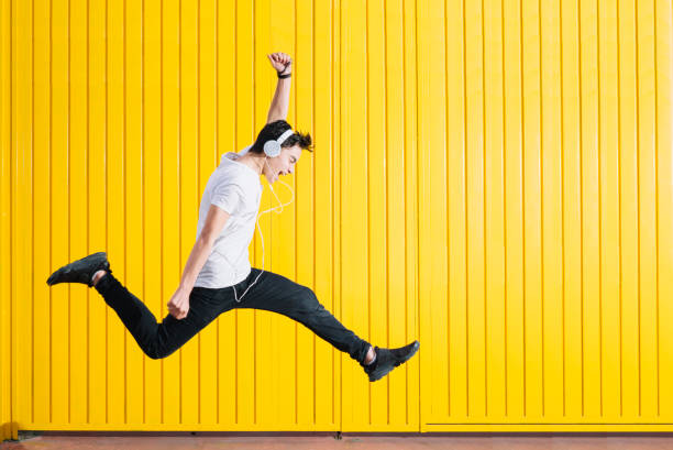 teen with headphones and smartphon listening to music jumping - fashion stock pictures, royalty-free photos & images