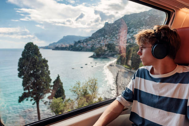 teenage boy travelling by train in french riviera - travel stock-fotos und bilder