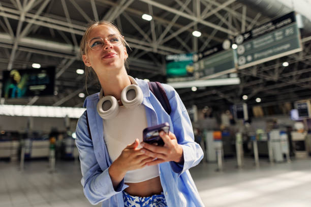 teenage girl at the airport and using smartphone - travel stock pictures, royalty-free photos & images