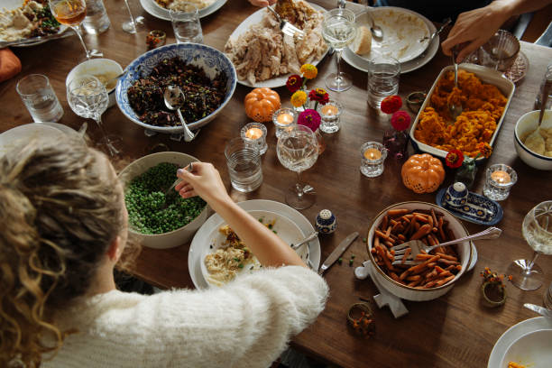 teenage girl having food while sitting at dining table during thanksgiving - home decoration stock pictures, royalty-free photos & images