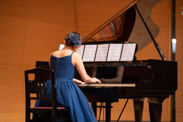 teenage girl playing piano at concert hall - concert stock pictures, royalty-free photos & images