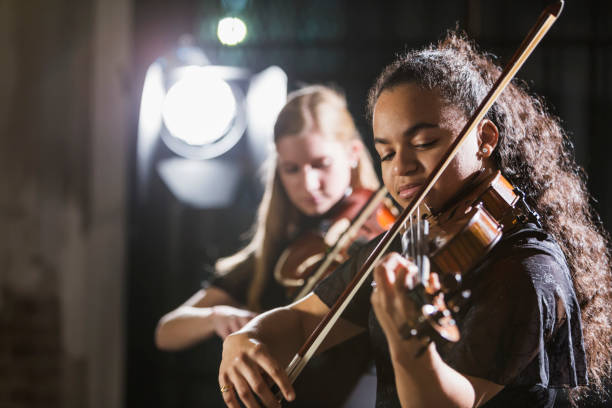 teenage girls playing violin in concert - concert stock pictures, royalty-free photos & images